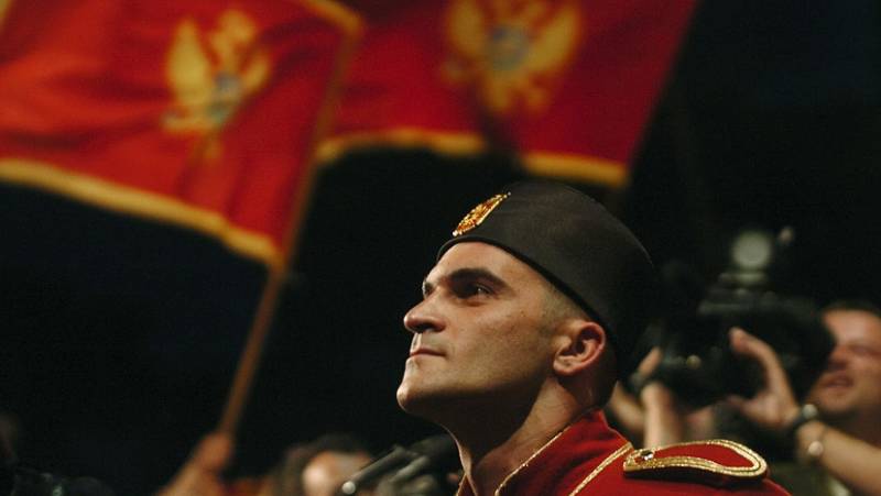 Солдат национальной гвардии на фоне флага Черногории перед зданием парламента в Подгорице AFP